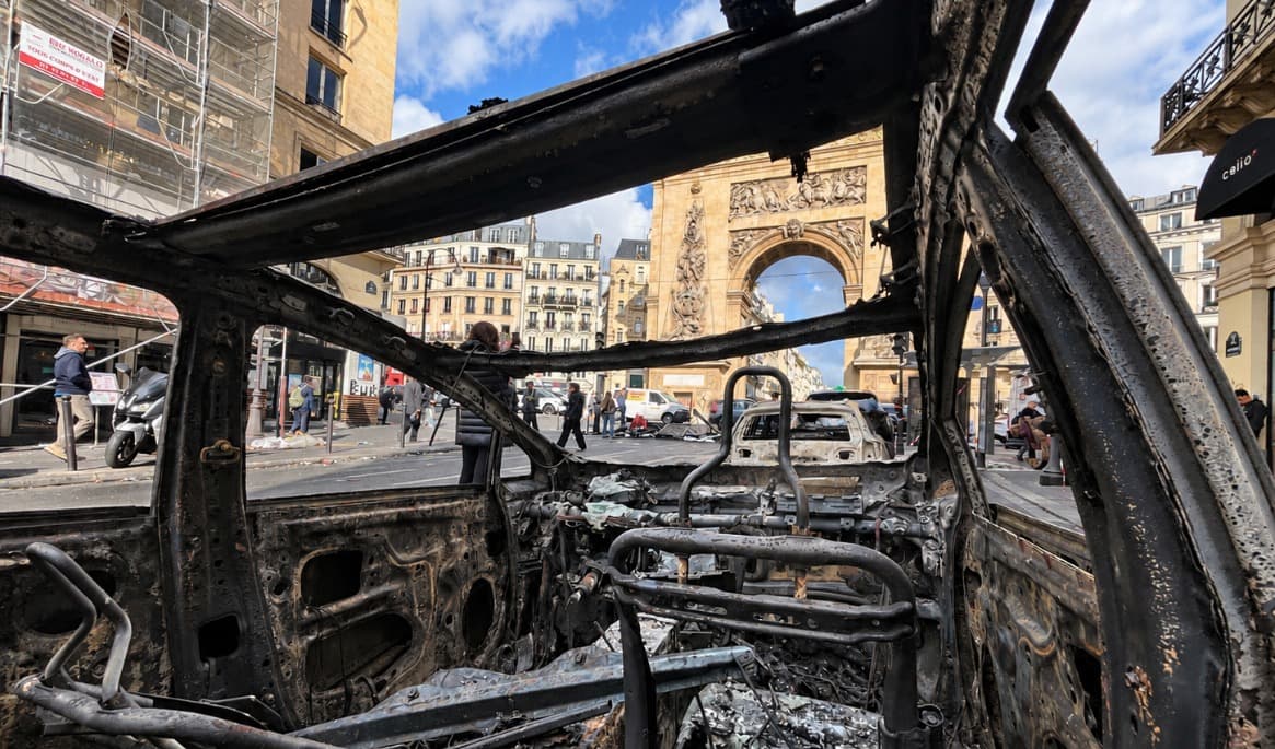 En utbrunnen bil vid monumentet Porte Saint-Denis i Paris den 18 oktober 2026, dagen efter att våldsamma protester och omfattande förstörelse drabbat den franska huvudstaden. Foto: Etienne Fauchaire