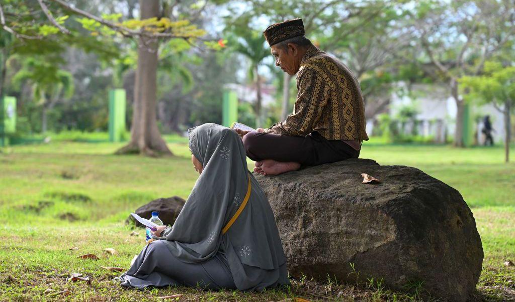 Paret sitter vid en plats för tsunamioffer i Banda Aceh, Indonesien. För 18 år sedan drabbades Indiska oceanen av mycket kraftiga jordskalv väster om Sumatra. Flodvågor vällde in, Många svenskar i Thailand drabbades hårt, 543 dog, 1500 skadades. Foto: Chaideer Mahyuddin/AFP via Getty Images