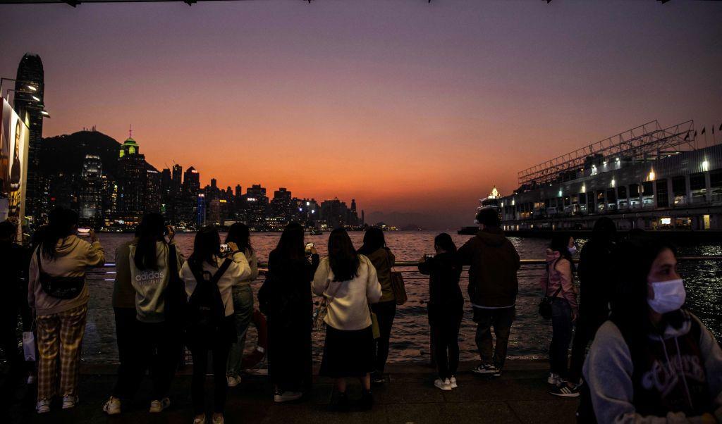 
I Hongkong samlas folk vid Tsim Sha Tsui för att titta på solnedgången över Victoria hamnen, den 30 december. Foto: Isaac Lawrence/AFP via Getty Images                                            