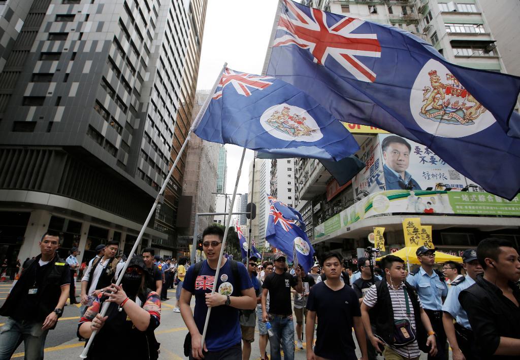 Demonstranter utrustade med Hongkongs kolonialflagga vid demokrati-aktivisternas årliga marsch, som hölls den 1 juli i år. (Foto: Kin Cheung/AP/TT)