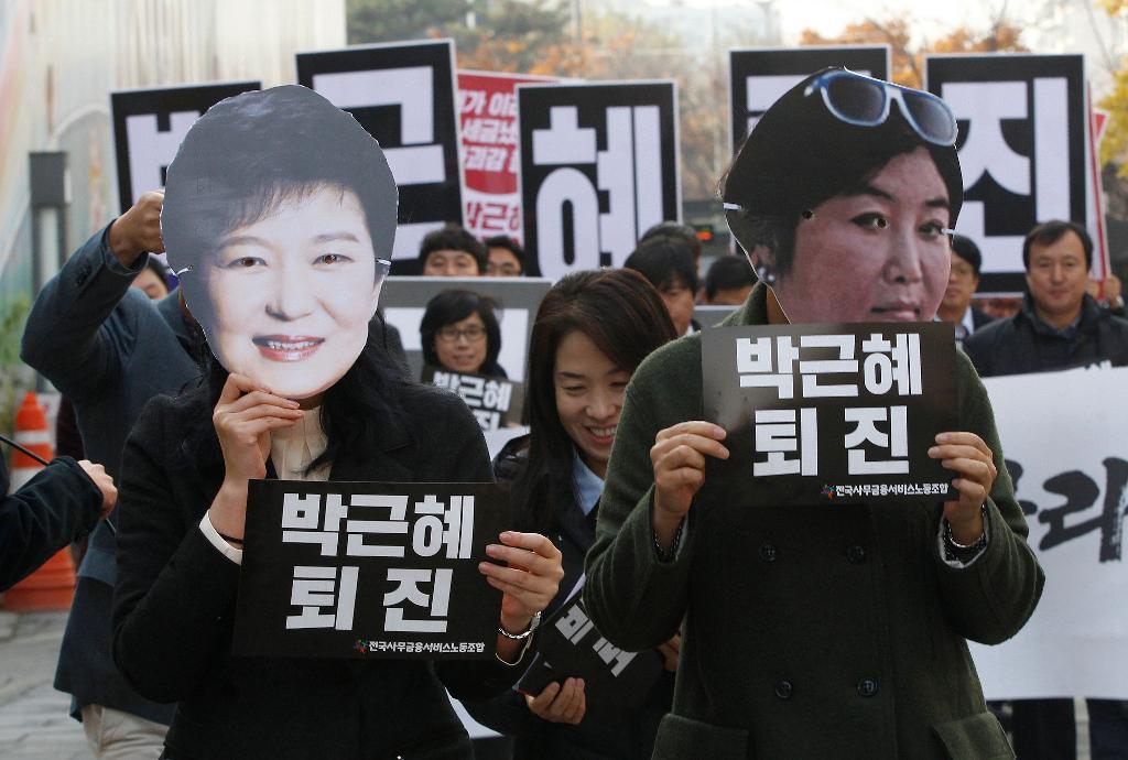Demonstranter med masker föreställande Sydkoreas president Park Geun-Hye (vänster) och hennes vän och livscoach Choi Soon-Sil (höger). (Foto: Ahn Young-Joon/AP/TT-arkivbild)