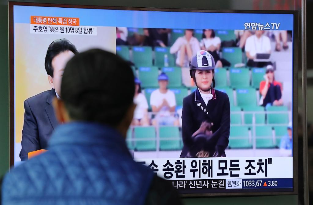 En man i Sydkorea tittar på tv-nyheter om gripandet av tävlingsryttaren Chung Yoo-Ra, dotter till den korruptionsanklagade Choi Soon-Sil, som är nära vän till president Park Geun-Hye. (Foto: Lee Jin-man/AP/TT)