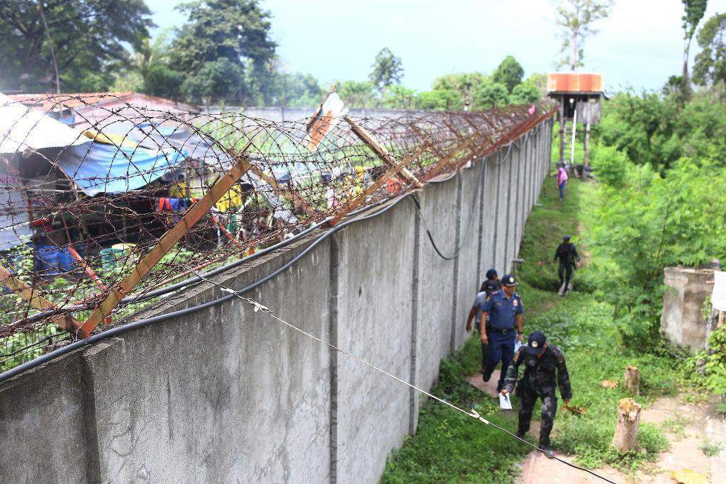Poliser utanför murarna till fängelset i Kidapawan i Filippinerna. (Foto: STR/AP/TT)