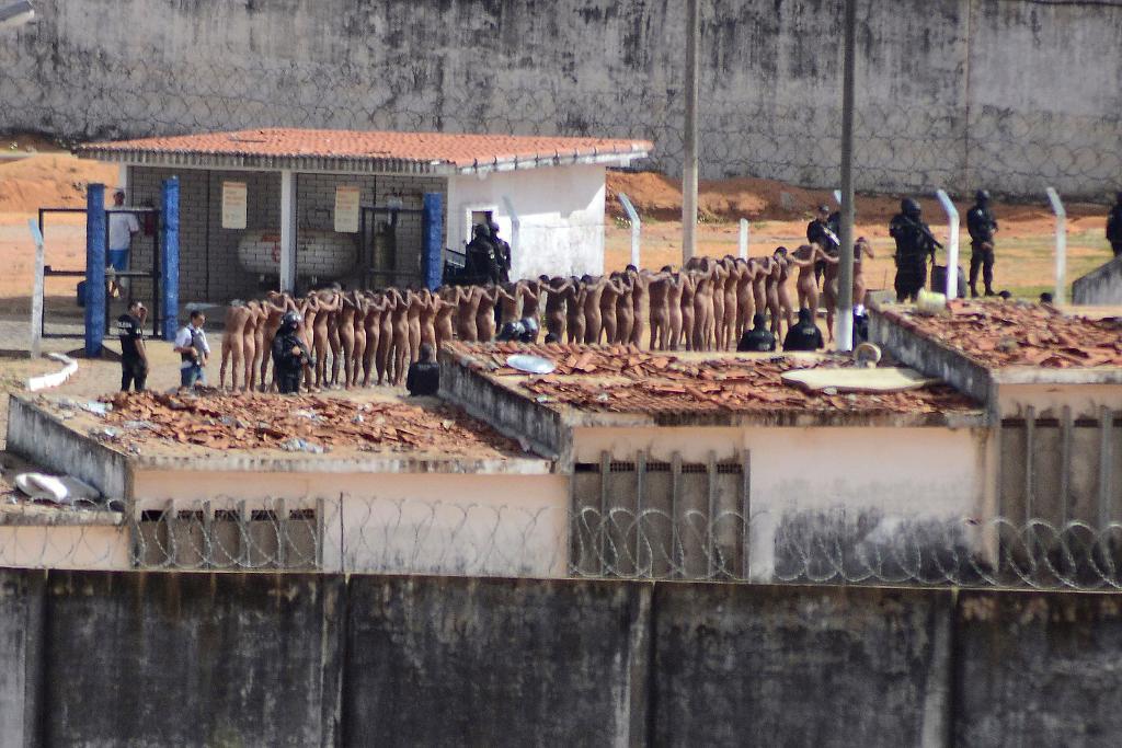 Nakna fångar omringade av poliser den 15 januari efter ett fängelseupplopp i delstaten Natal i Brasilien. (Foto: Frankie Marcone/Futura Press/AP/TT)
