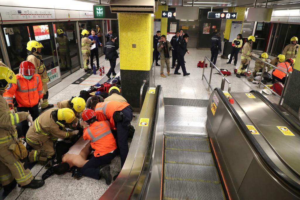 Tunnelbaneresenärer som skadades i attacken får vård av räddningspersonal på stationen Tsim Sha Tsui i Hongkong. Foto: AP/TT