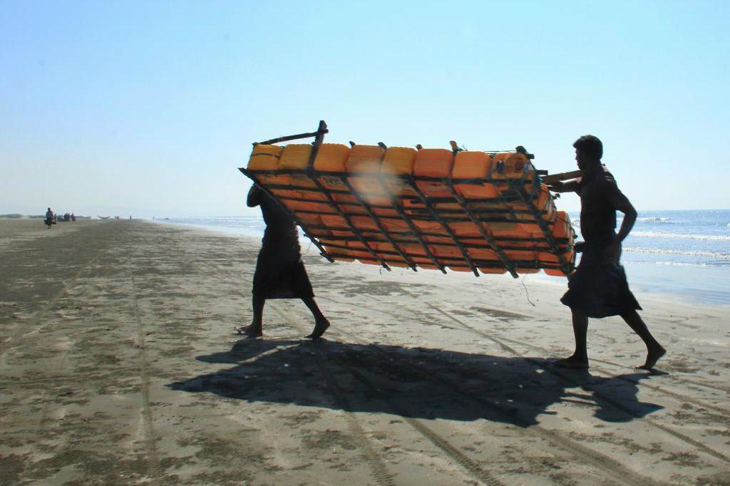 
Fiskare tillhörande rohingya bär upp sin flotte gjord av platsdunkar.  Foto: Esther Htusan /AP/TT-arkivbild                                            