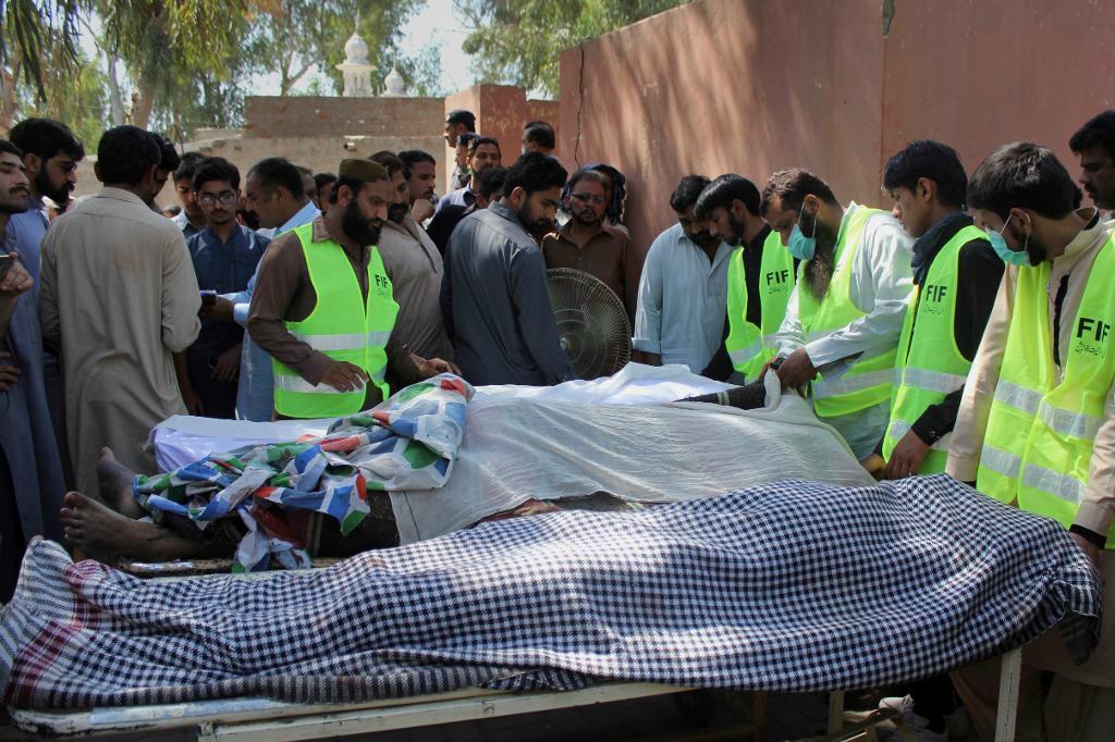 Pakistanska volontärer och ortsbor tar hand om de döda kropparna. Foto: M I Haq/AP/TT