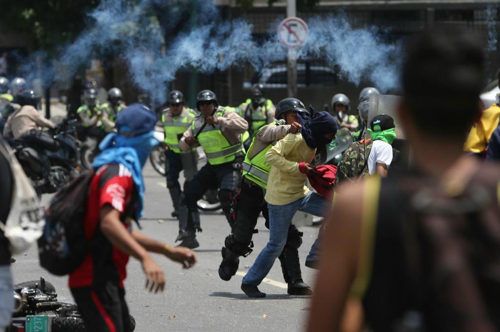 
Demonstranter och polis drabbar samman vid protester i Caracas under måndagen. Foto: Fernando Llano/AP/TT                                            