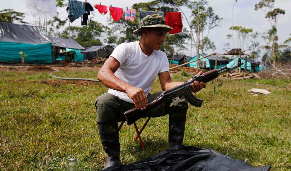 
En medlem i Farc-gerillan rengör sitt vapen. Foto: Fernando Vergara/AP/TT-arkivbild                                            