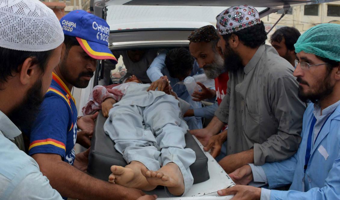 Frivilliga hjälper en skadad till sjukhus efter den stora explosionen i pakistanska Quetta. Foto: Banaras Khan/AFP/Getty Images