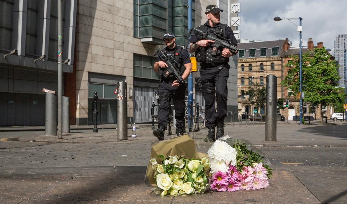Beväpnade poliser patrullerar i Manchester den 23 maj 2017 samtidigt som folk lägger blommor på gatan för att hedra de skadade och döda. (Foto: Christopher Furlong/Getty Images).
