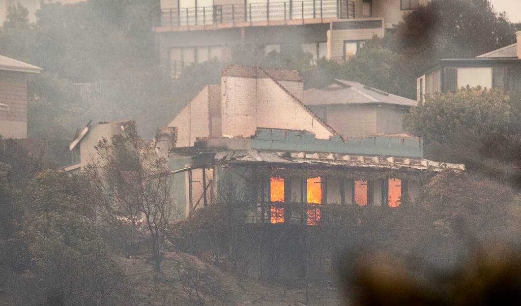 Brinnande hus i kuststaden Plettenberg Bay, en populär semesterort. Foto: Ewald Stander/AP/TT