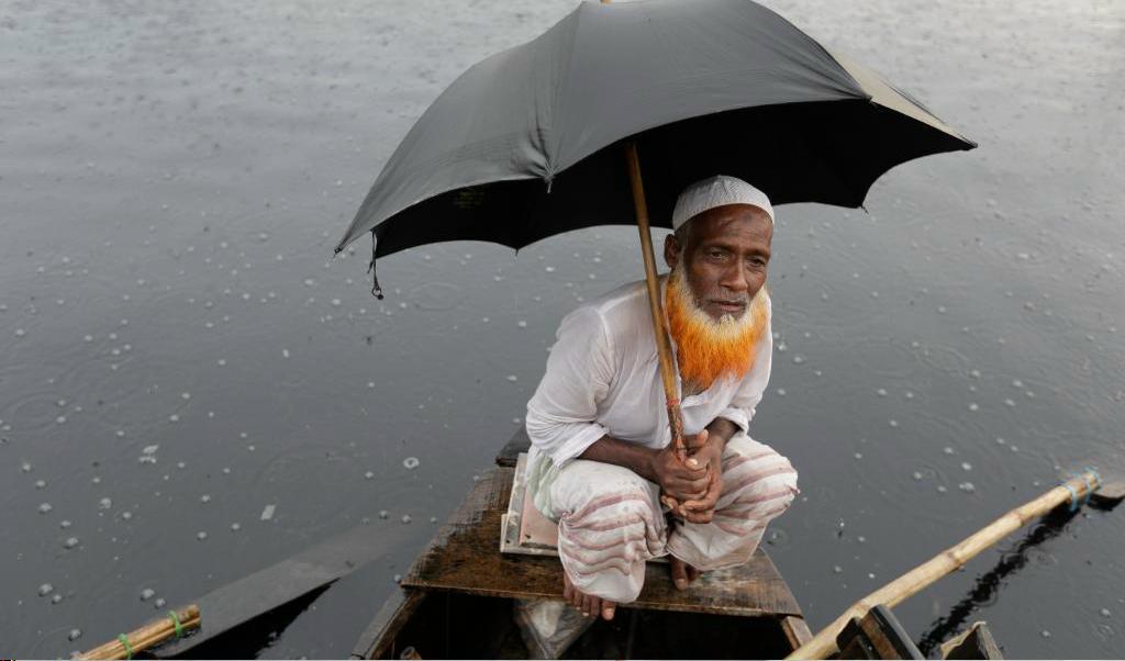 Här sitter Shuruj Ali och väntar på passagerare till sin båt på floden Buriganga i Dhaka. Foto: A.M. Ahad/AP/TT