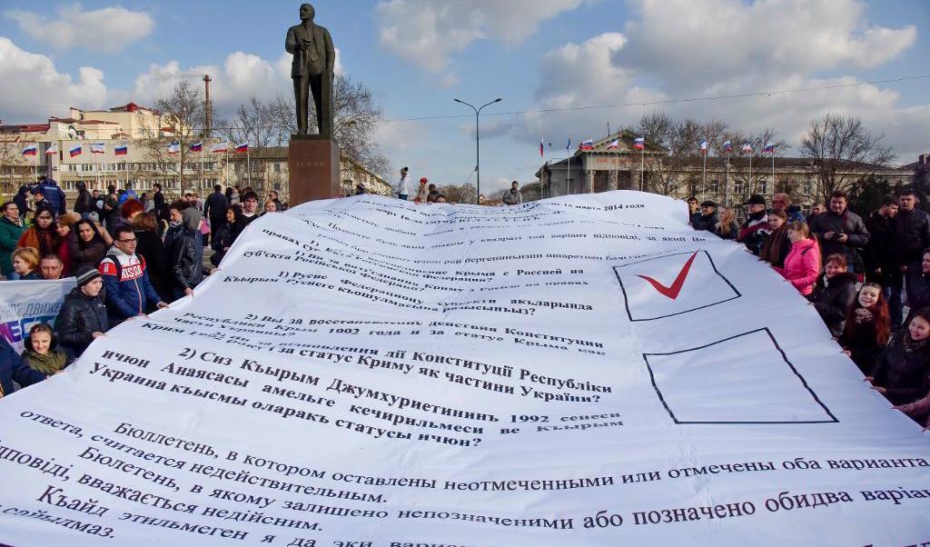 
En uppförstorad röstsedel från folkomröstningen om Krimhalvön 2014 hålls upp på treårsdagen i våras. Omröstningen dömdes ut i västvärlden, men gjorde att Ryssland nu anser sig ha rätt till området. Foto: TT-arkivbild                                            