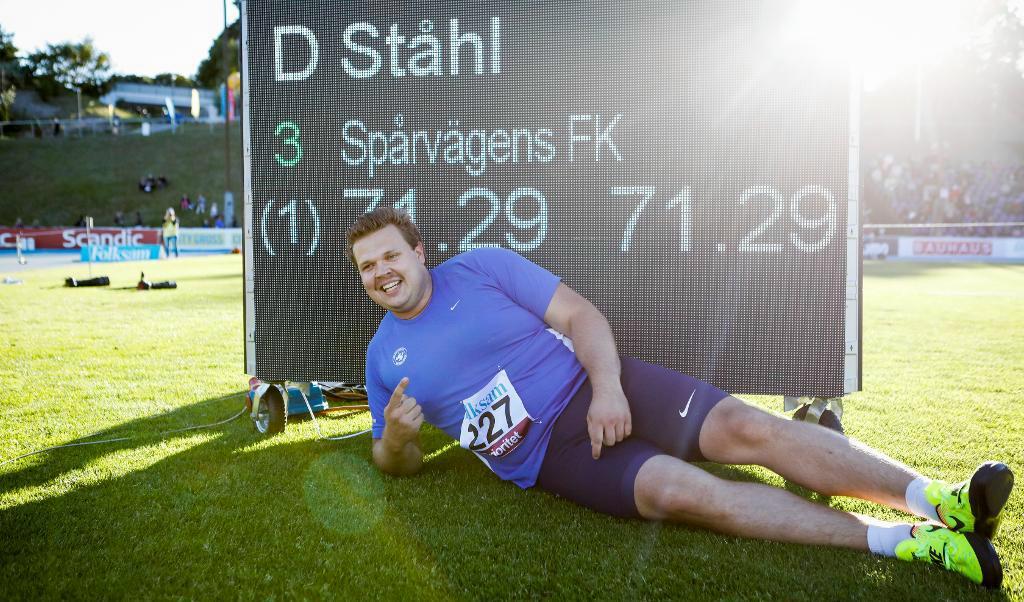 Daniel Ståhl poserar framför resultattavlan som visar det nya svenska rekordet i diskus. Foto: TT