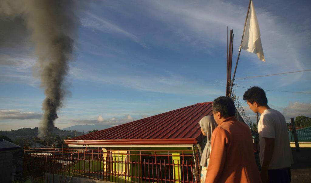 Civila betraktar regeringens flygbomningar mot extremister i staden Marawi i Filippinerna. Arkivbild. Foto: Linus G. Escandor ll/AP/TT