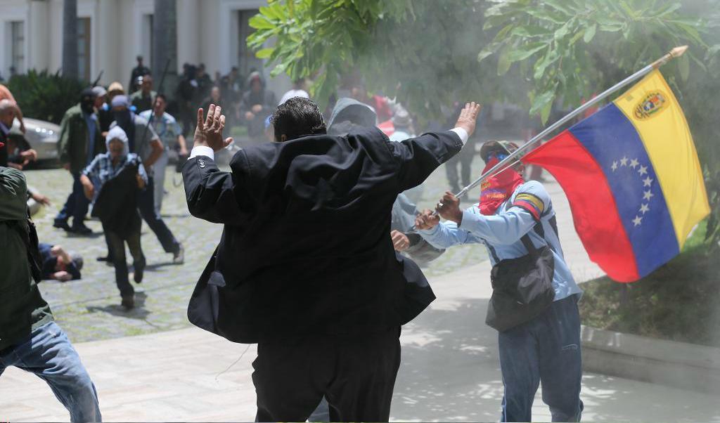 Parlamentsledamoten Franco Casella från oppositionella Vente Venezuela attackeras av aktivister som stöder president Nicolas Maduro. Foto: TT