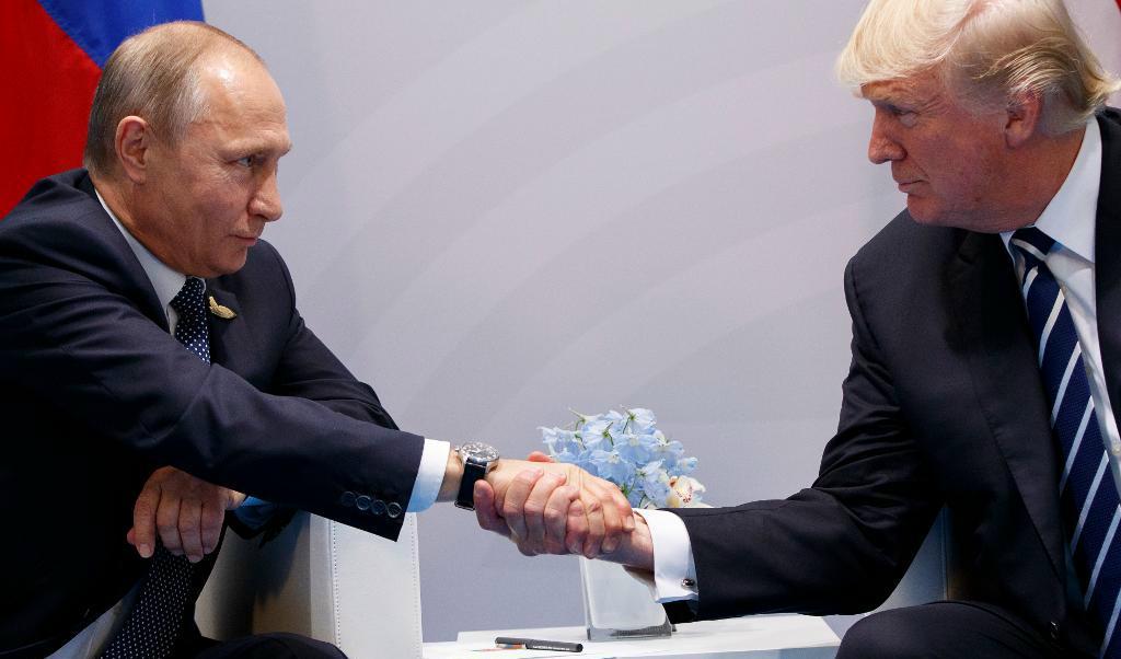 
USA:s president Donald Trump och Rysslands president Vladimir Putin skakar hand under sitt första möte öga mot öga i Hamburg under G20-mötet. Foto: Evan Vucci /AP/TT                                            