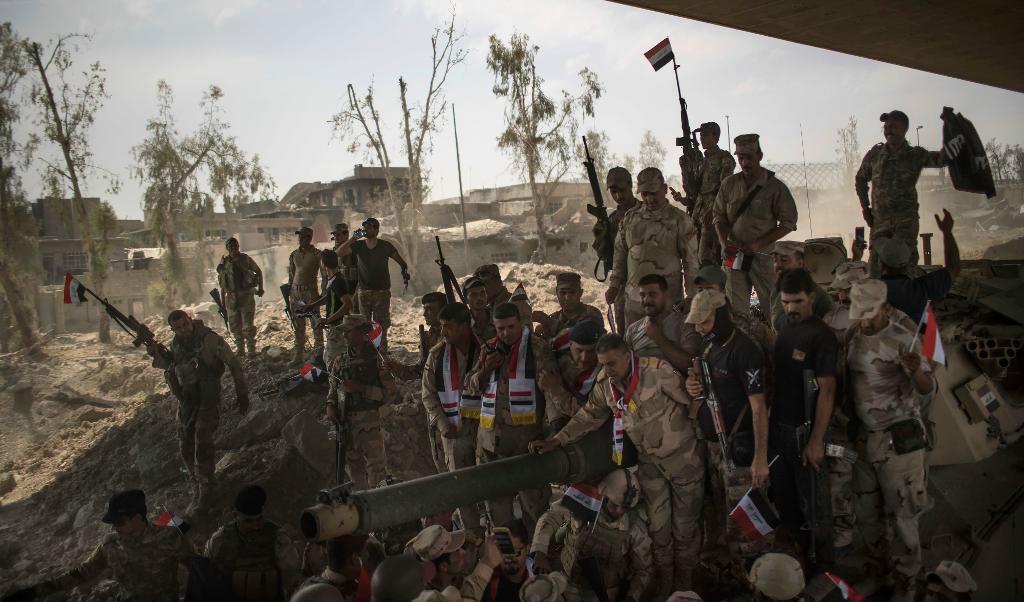 Irakiska armésoldater samlade för att fira sin framryckning mot Islamiska staten (IS) i Mosuls gamla stad. Foto: Felipe Dana/AP/TT