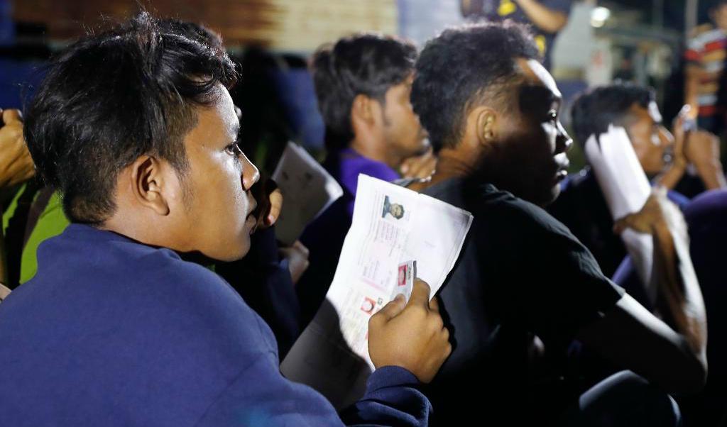 
Utländska arbetare väntar på att få sina dokument godkända av malaysiska myndigheter. Foto: Vincent Thian/AP/TT                                            