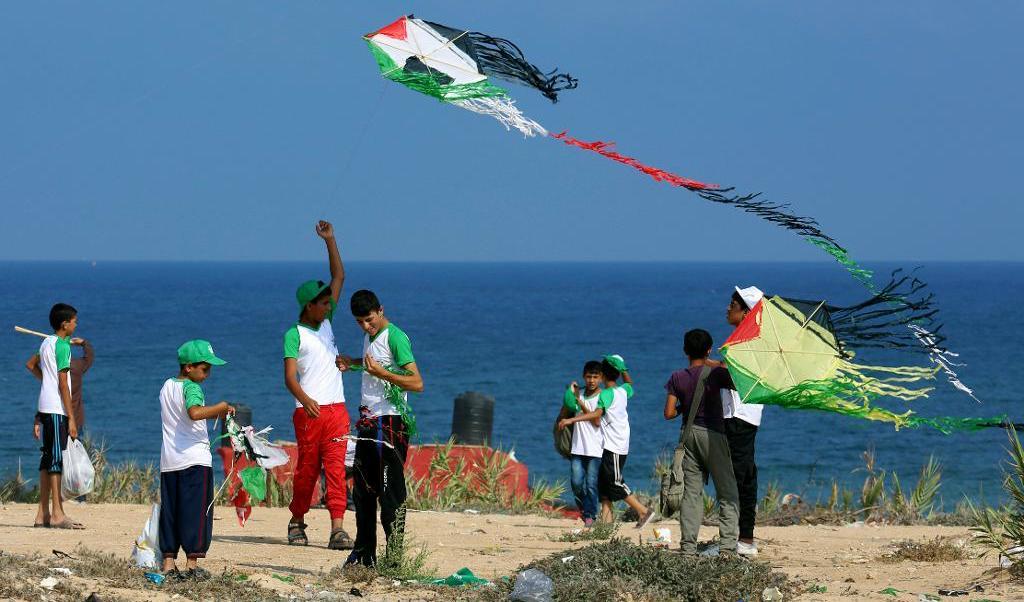 
Palestinska ungdomar flyger drake i Gazaremsan, på ett sommarläger med Hamasstöd. Drakarna bär den palestinska flaggans färger: grönt, rött, svart och vitt. Foto: Adel Hana/AP/TT-arkivbild                                            