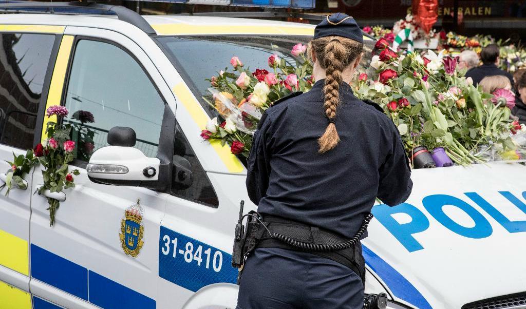 En polisbil överöst med blommor utanför Åhlens på Drottninggatan, tre dagar efter terrordådet i Stockholm city. Arkivbild. Foto: Christine Olsson/TT