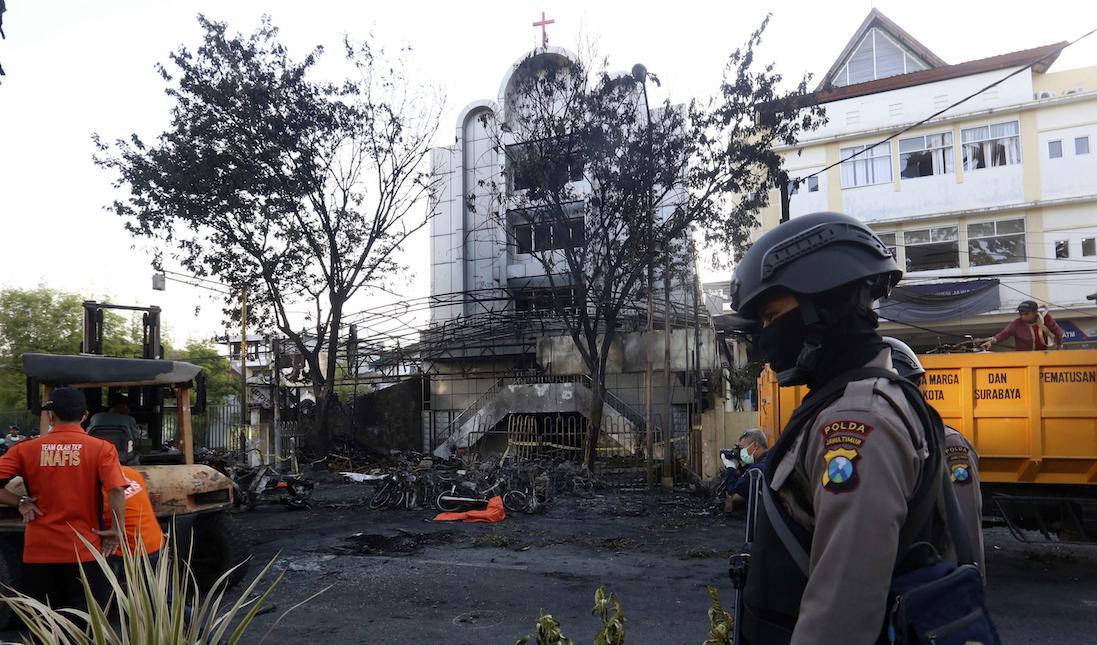 En polis utanför en av kyrkorna som utsattes för ett självmordsdåd i Surabaya. Foto: AP/TT