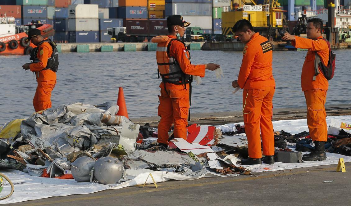 Indonesisk sökpersonal undersöker föremål i närheten av platsen där det indonesiska passagerarflygplanet störtat. Foto: AP/TT