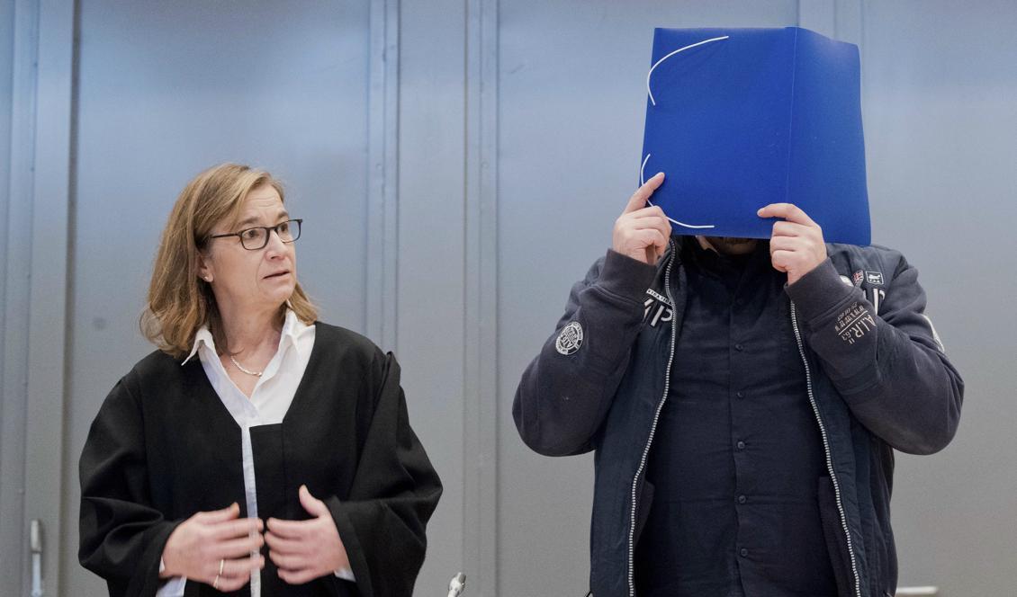 Niels Högel döljer sitt ansikte när han och hans advokat Ulrike Baumann anländer till rättegången i Oldenburg, Tyskland. Foto: Julian Stratenschulte/AP/TT