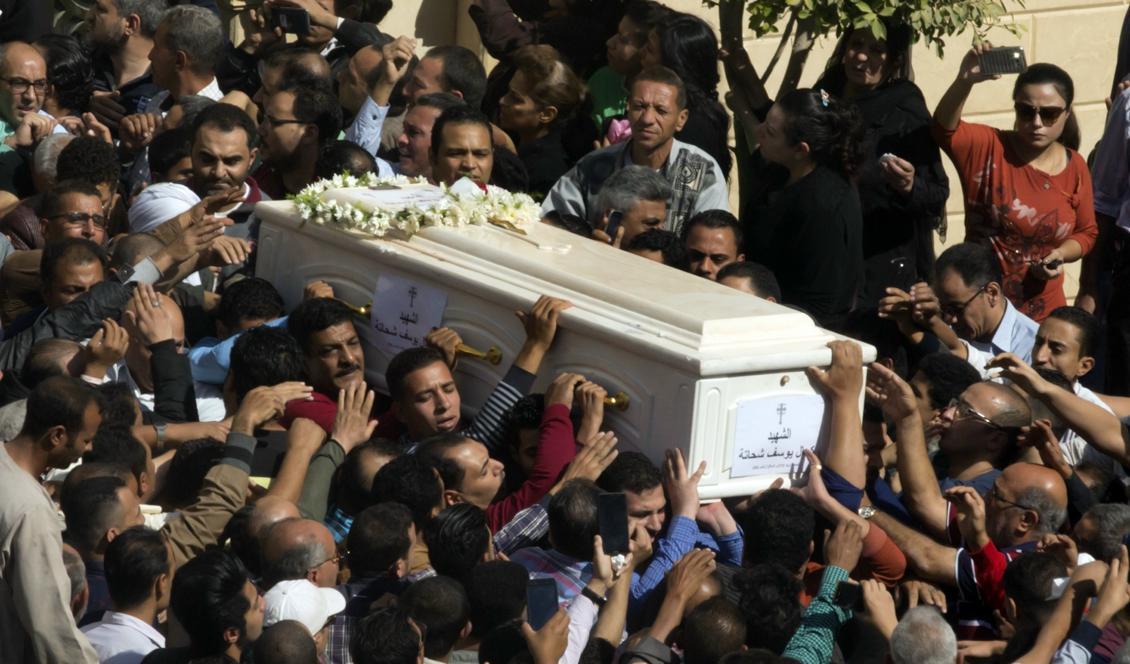 Anhöriga till offren för fredagens attack bär kistor med de döda. Foto: Amr Nabil/AP/TT