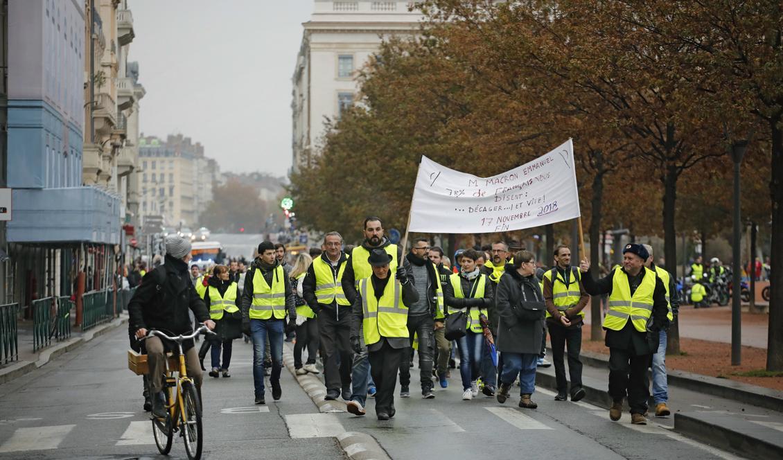 Människor protesterar mot höjda skatter på bensin och diesel i centrala Lyon. Foto: Laurent Cipriani/AP/TT