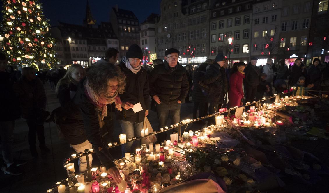 Invånare i Strasbourg tänder ljus och lägger ner blommor för att hedra offren. Foto: Jean-Francois Badias/AP/TT