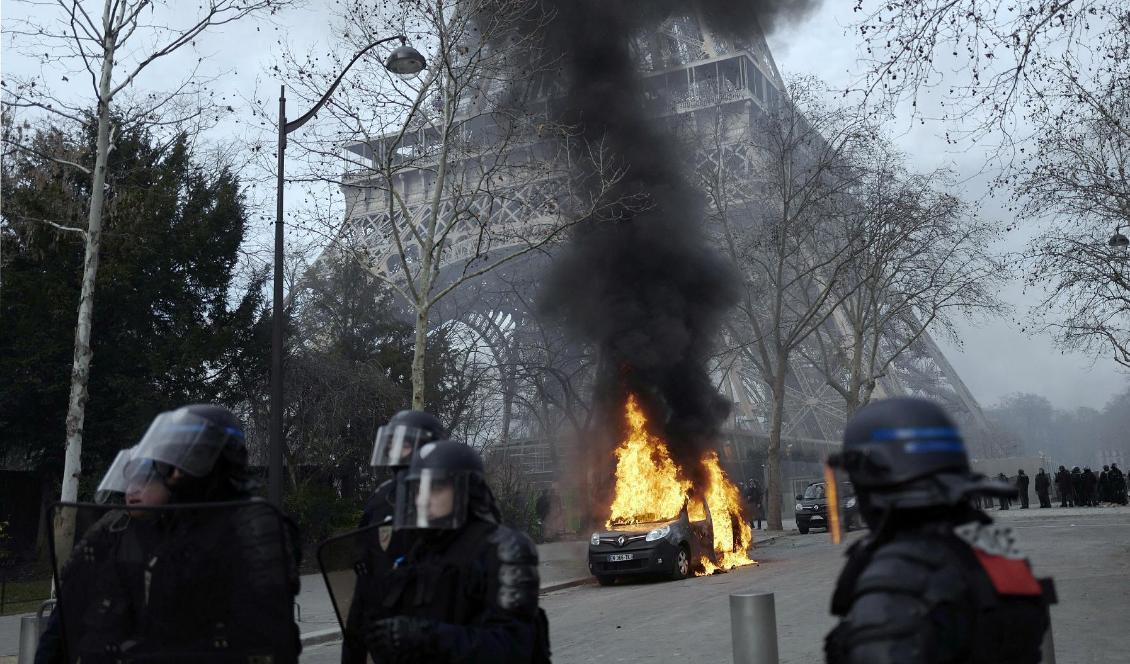 Ett polisfordon som stuckits i brand intill Eiffeltornet i Paris. Foto: Kamil Zihnioglu/AP/TT