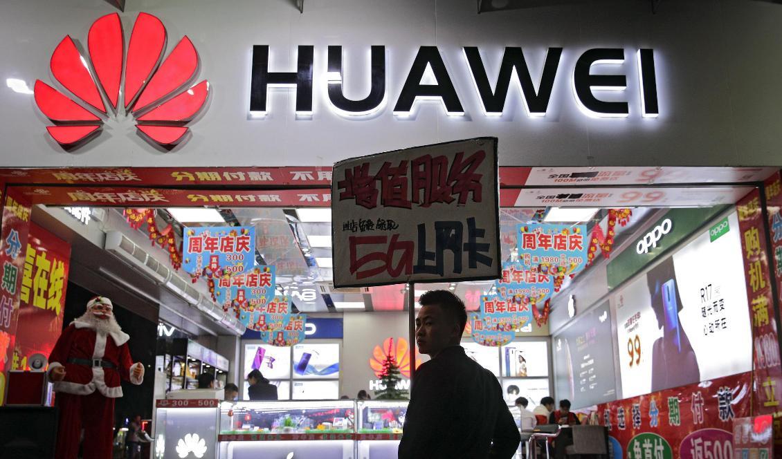 Två anställda vid kinesiska mobiltillverkaren Huawei fick knappast något gott nytt år. Foto: Andy Wong/AP/TT-arkivbild