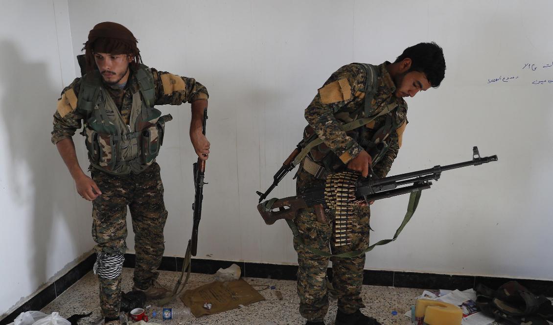 En arabisk (till höger) och en kurdisk medlem i den USA-stödda SDF-milisen. Foto: Hussein Malla/AP/TT-arkivbild