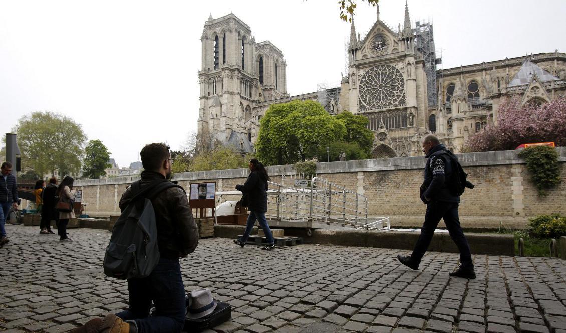 
En man knäböjer framför Notre-Dame på tisdagen. Foto: Christophe Ena/AP/TT                                                