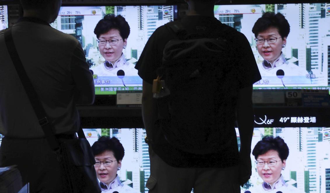 
Hongkong-bor tittar på sändningen på lördagen då Carrie Lam meddelade att det omstridda lagförslaget pausas. Foto: Vincent Yu/AP/TT                                                