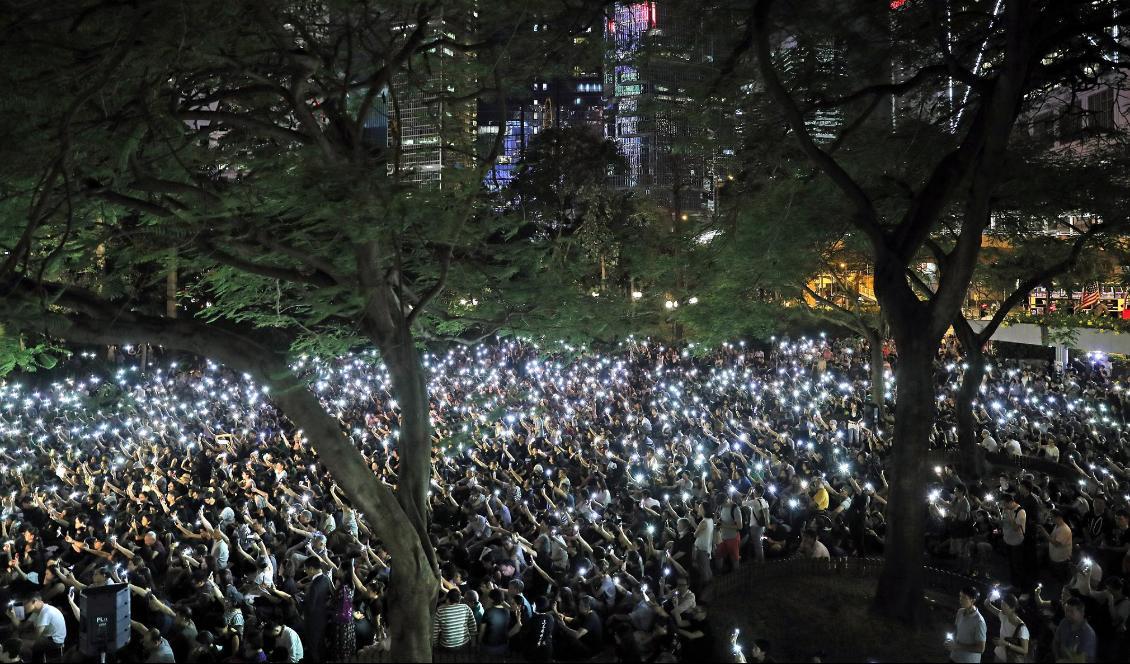 
Människor håller upp sina lysande mobiltelefoner vid en demonstration i fredags. Foto: Kin Cheung/AP/TT                                                