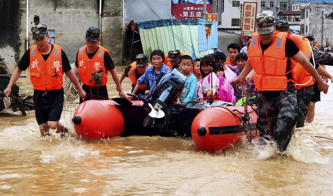 Kinesisk paramilitär polis evakuerar människor efter översvämningar i Heyuan i södra Kina 10 juni 2019. Foto: AP/TT-arkivbild