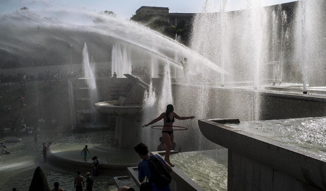Människor svalkar sig i fontänen i parken Trocadero i Paris. Foto: Rafael Yaghobzadeh/AP/TT