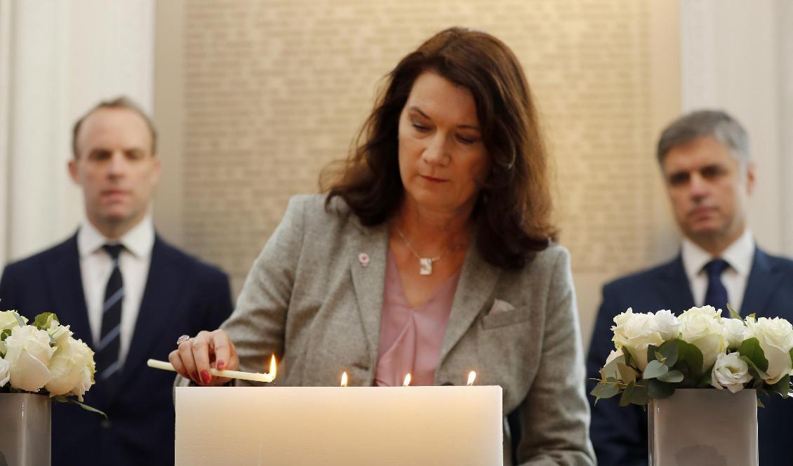 Utrikesminister Ann Linde (S) tänder ett ljus framför en minnesskylt med namnen på de som dödades i nedskjutningen av det ukrainska passagerarflygplanet i Iran. Foto: Frank Augstein/AP/TT