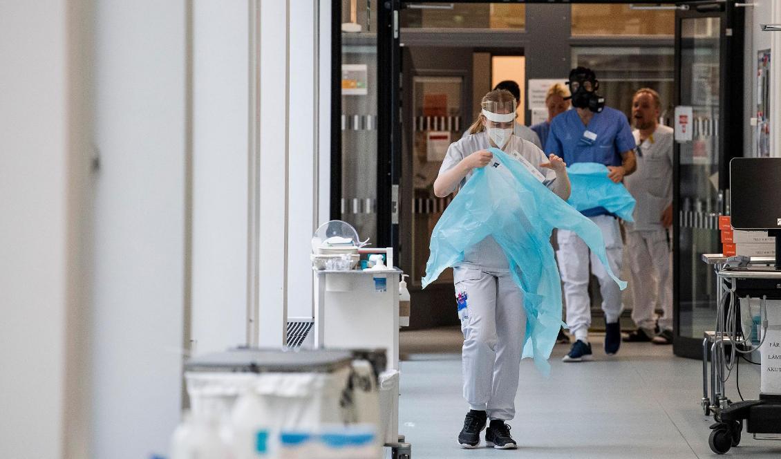 Sjukvårdspersonal tar på sig skyddsutrustning då de gör sig redo att ta emot en patient till intensivvårdsavdelningen i Danderyds sjukhus den 13 april 2020. Foto: Jonathan Nackstrand/AFP via Getty Images