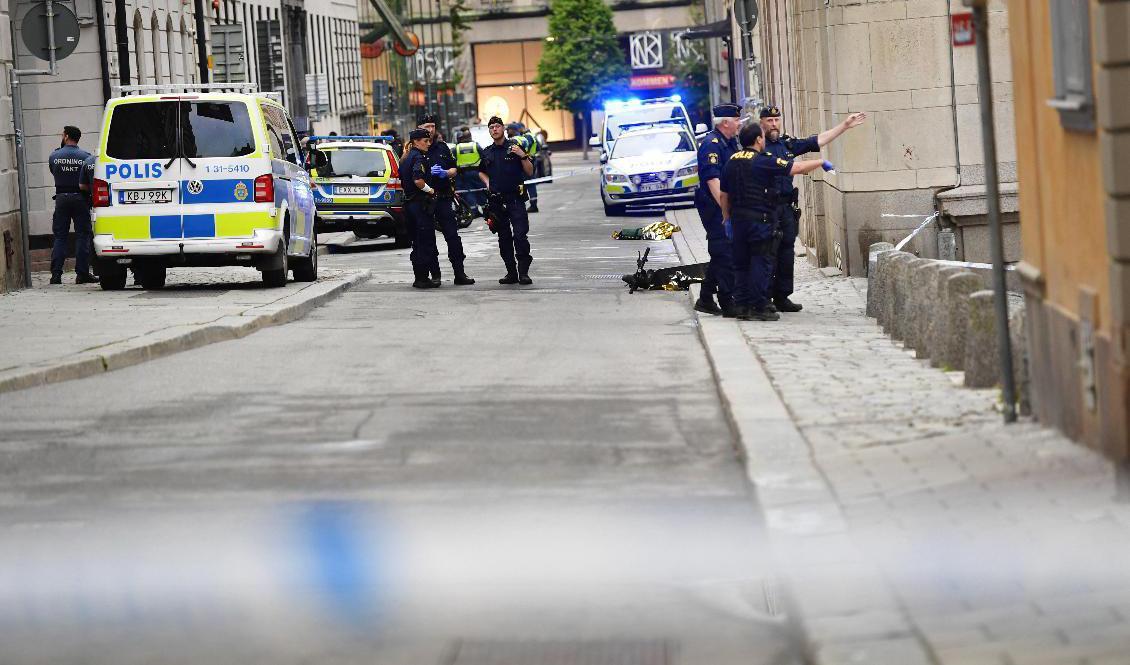 Polisen arbetar innanför avspärrningarna efter att flera personer knivhuggits i Kungsträdgården och på Västra Trädgårdsgatan i Stockholm. En person är gripen efter händelsen. Foto: Maja Suslin/TT