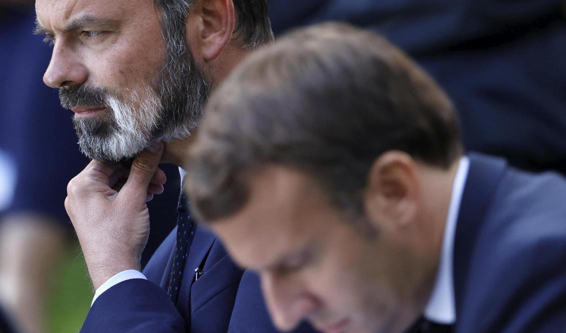 Frankrikes president Emmanuel Macron får ombilda sin regering då premiärminister Édouard Philippe (i bakgrunden) avgår. Foto: Christian Hartmann/AP/TT-arkivbild