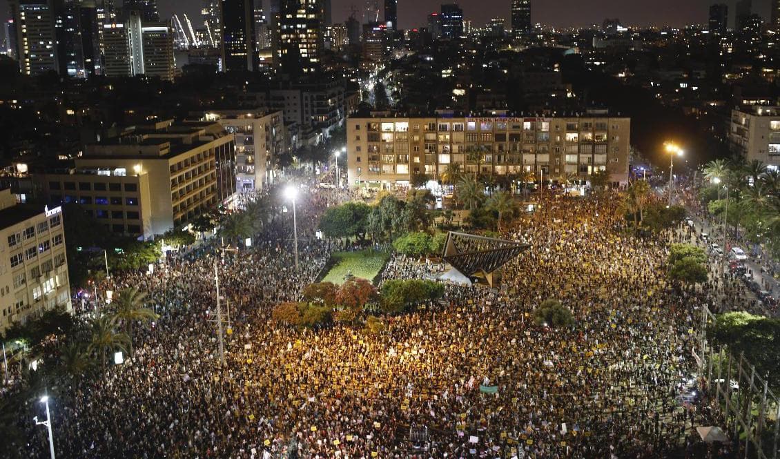 Tiotusentals demonstranter har samlats i Israels största stad Tel Aviv för att protestera mot regeringen och dess hantering av coronakrisen. Foto: Ariel Schalit/AP/TT
