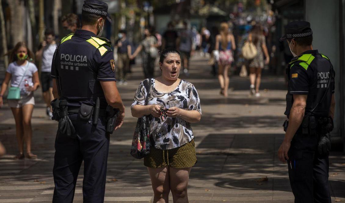 
Katalansk polis säger till en kvinna att det är obligatoriskt att bära munskydd. Foto: Emilio Morenatti/AP/TT-arkivbild                                            