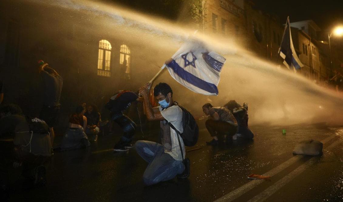 Polis försöker att skingra demonstranter som samlats utanför premiärminister Benjamin Nethanyahus bostad i Jerusalem. Foto: Oded Balilty/AP/TT