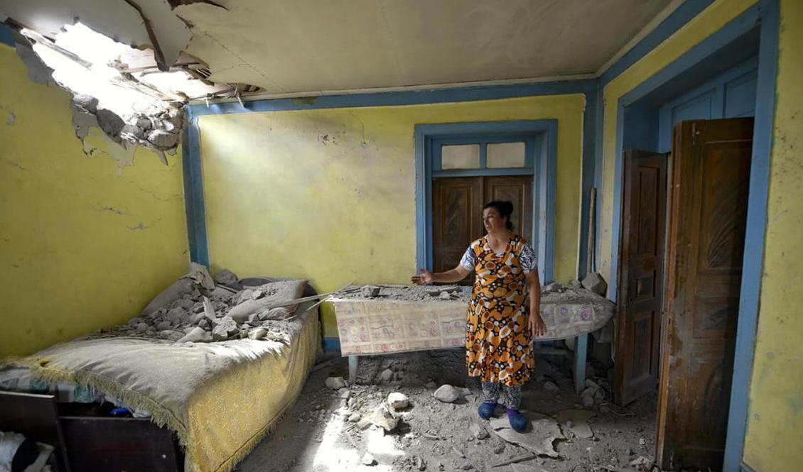 En kvinna i den azeriska Tovuz Rayonu-distriktet visar upp sitt hem som skadats i den senaste tidens stridigheter mellan Armenien och Azerbajdzjan. Foto: Ramil Zeynalov/AP/TT-arkivbild