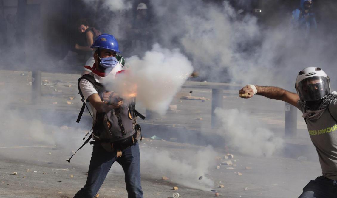 Demonstranter drabbar samman med polis på Martyrtorget i centrala Beirut. Foto: Hassan Ammar/AP/TT