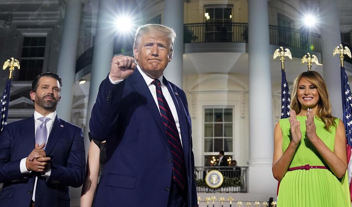 President Donald Trump flankerad av sonen Donald Trump Jr och presidentfrun Melania Trump. Foto: Evan Vucci/AP/TT